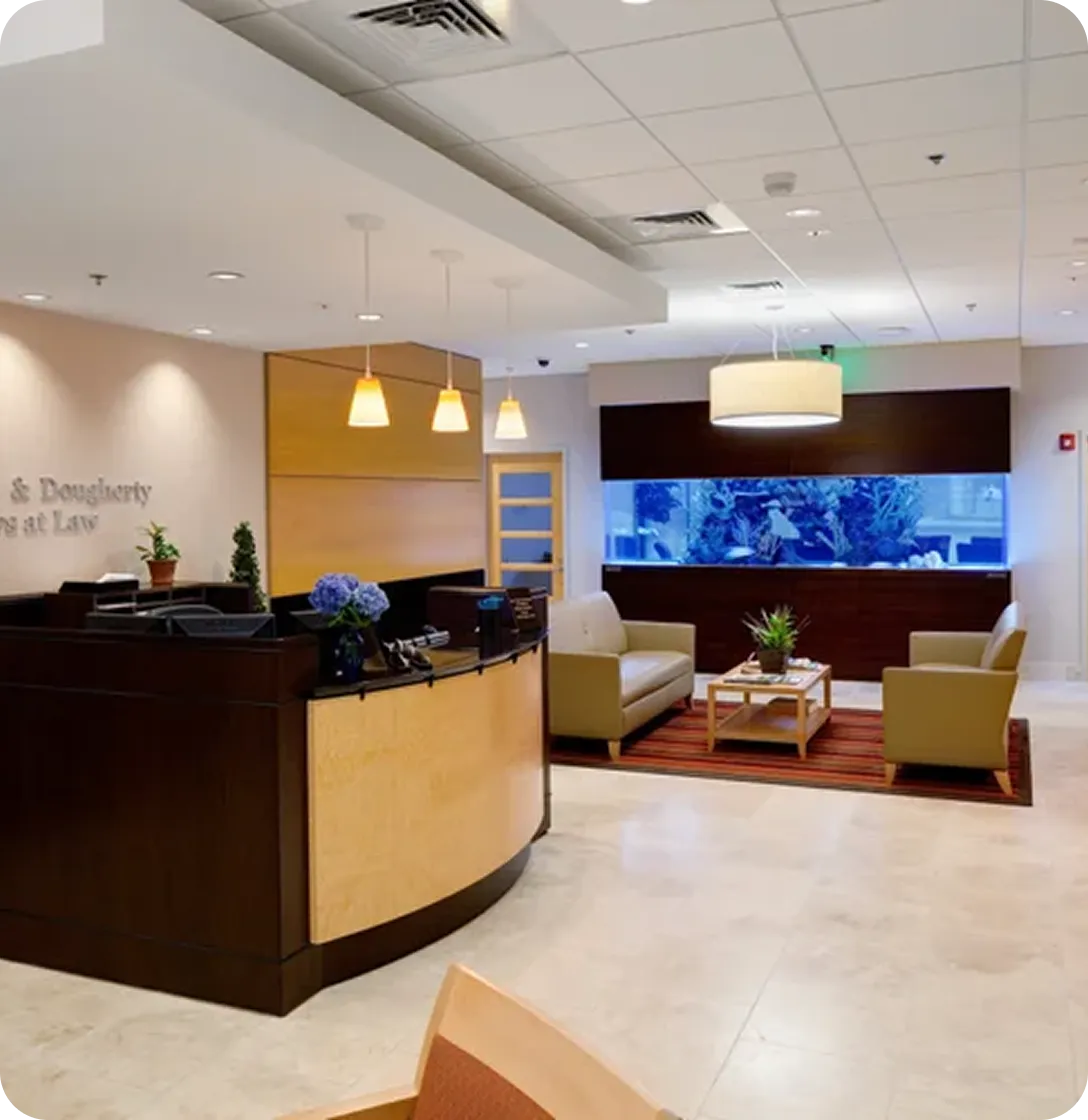 Reception area with wooden desk, beige seating, large aquarium, and pendant lighting.