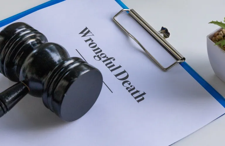 Black judge's gavel resting on a clipboard with a document titled "Wrongful Death.